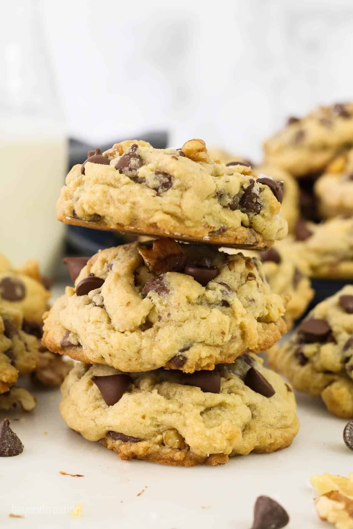 A stack of three chocolate chip and walnut cookies