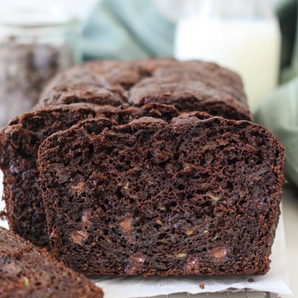A loaf of chocolate zucchini bread with some pieces sliced