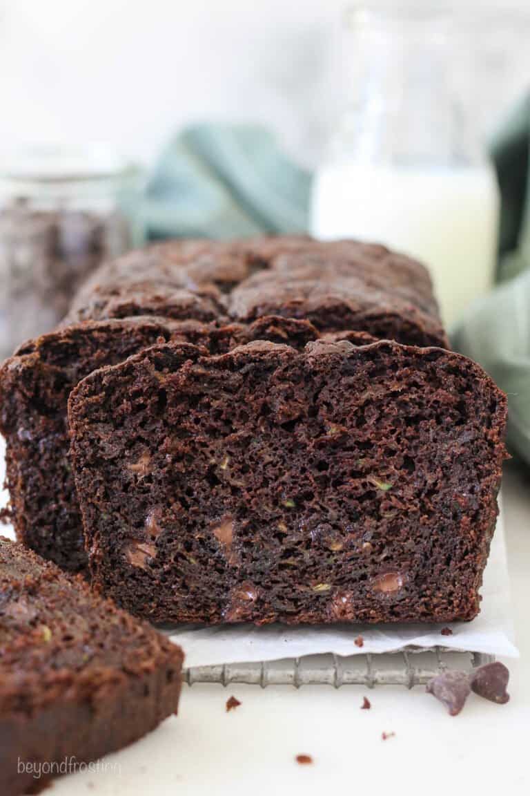 A loaf of chocolate zucchini bread with some pieces sliced