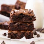 A stack of three cocoa powder brownies on a napkin