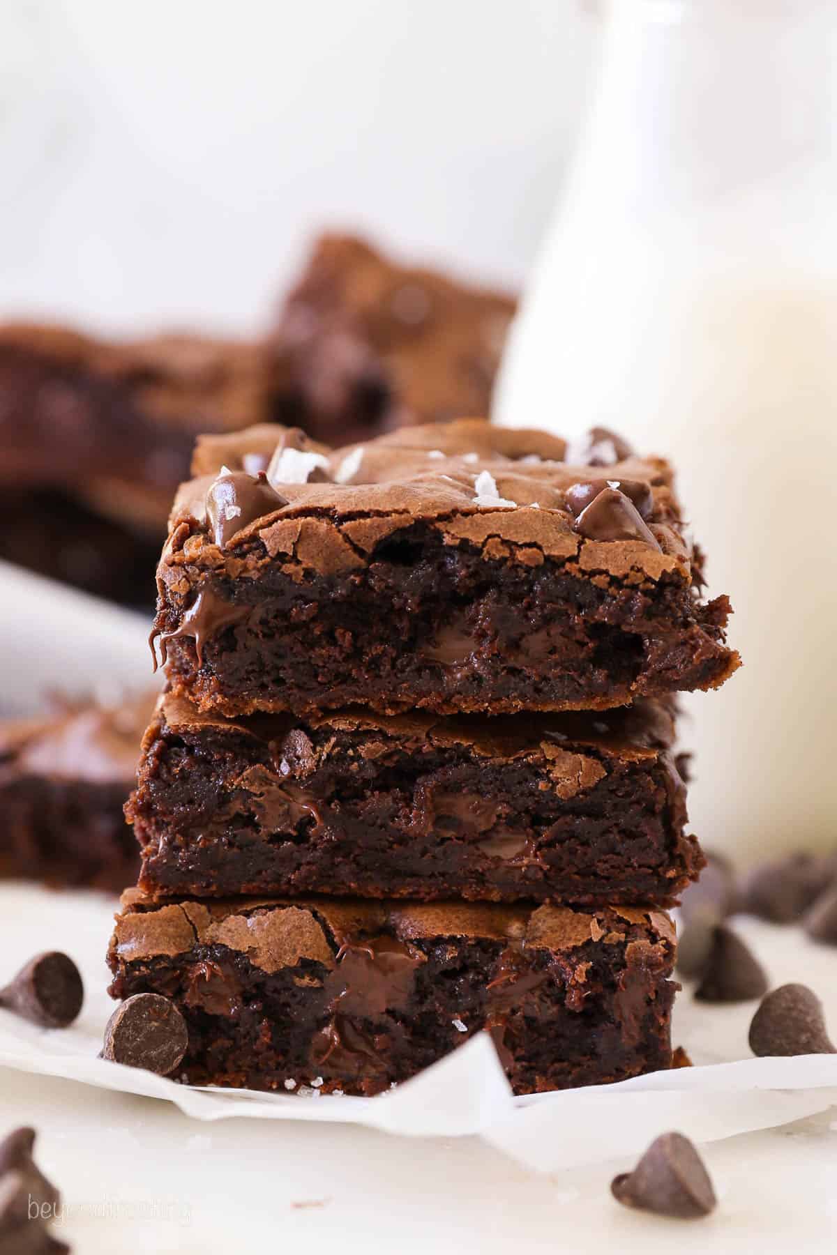 A stack of three cocoa powder brownies on a napkin