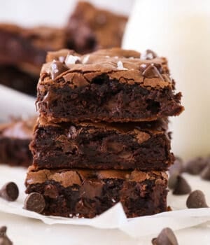 A stack of three cocoa powder brownies on a napkin