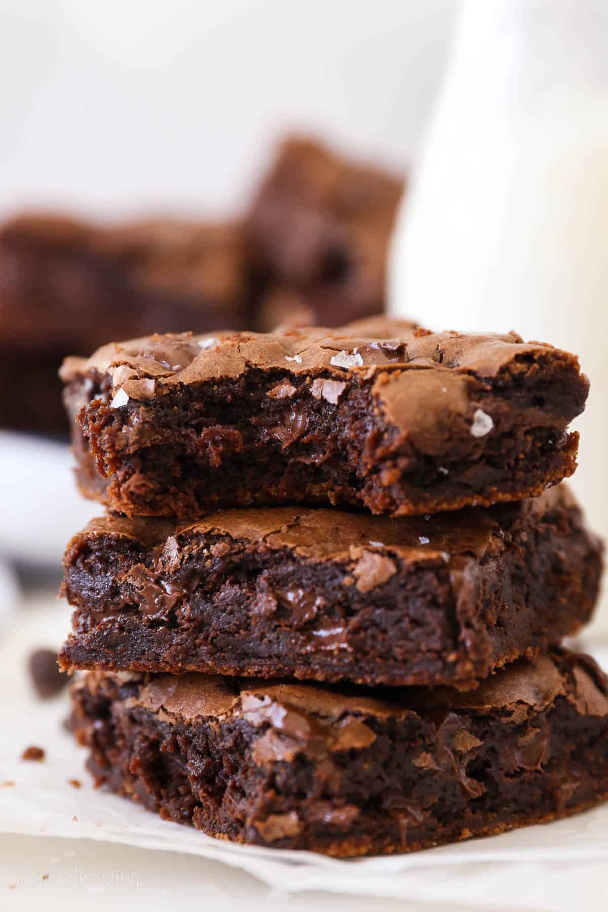 Three homemade brownies, the top one with a bite missing