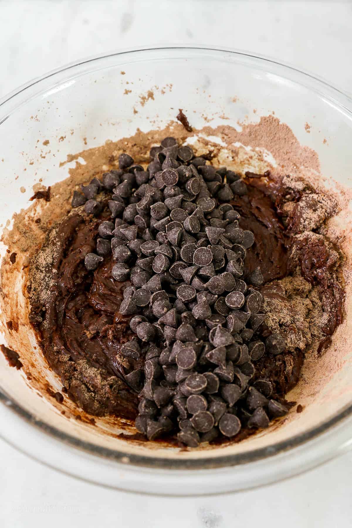 glass mixing bowl with brownie batter and chocolate chips