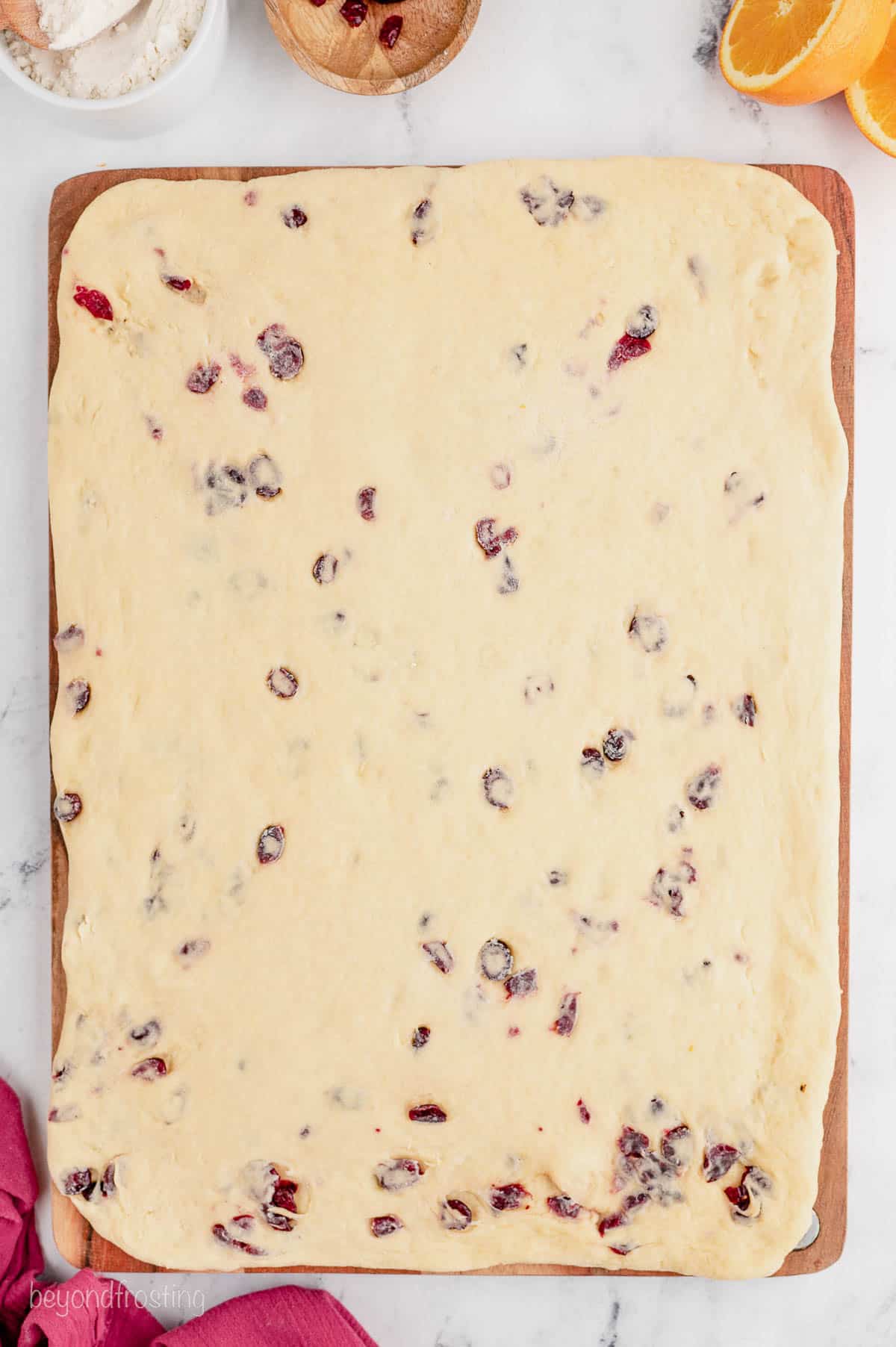 a rectangle of rolled out bread dough with cranberries