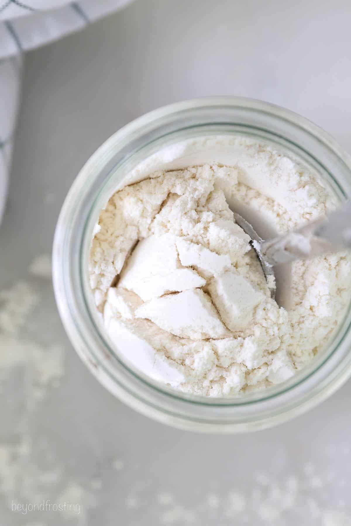 Overhead view of a spoon in a jar of flour