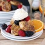 side view of a plate with french toast, whip, and fresh fruit