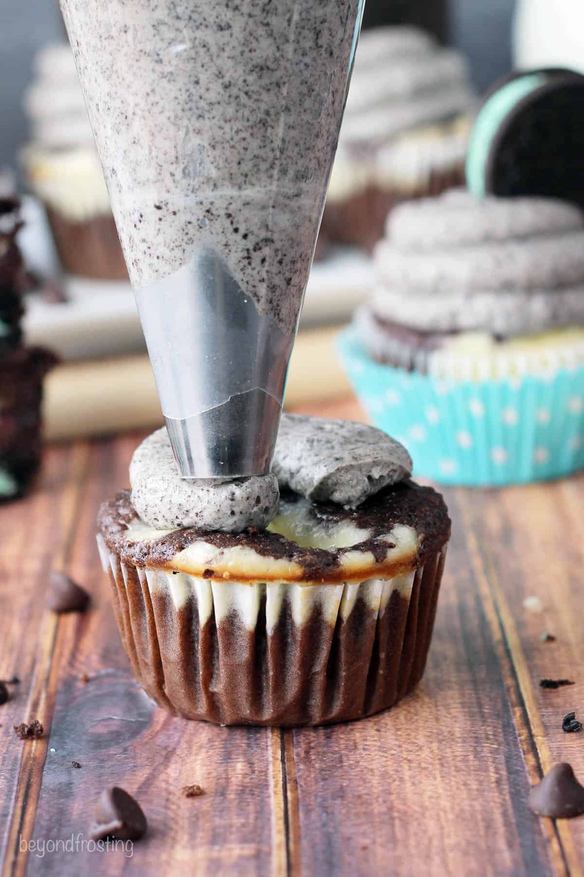 frosting being piped onto a cupcake