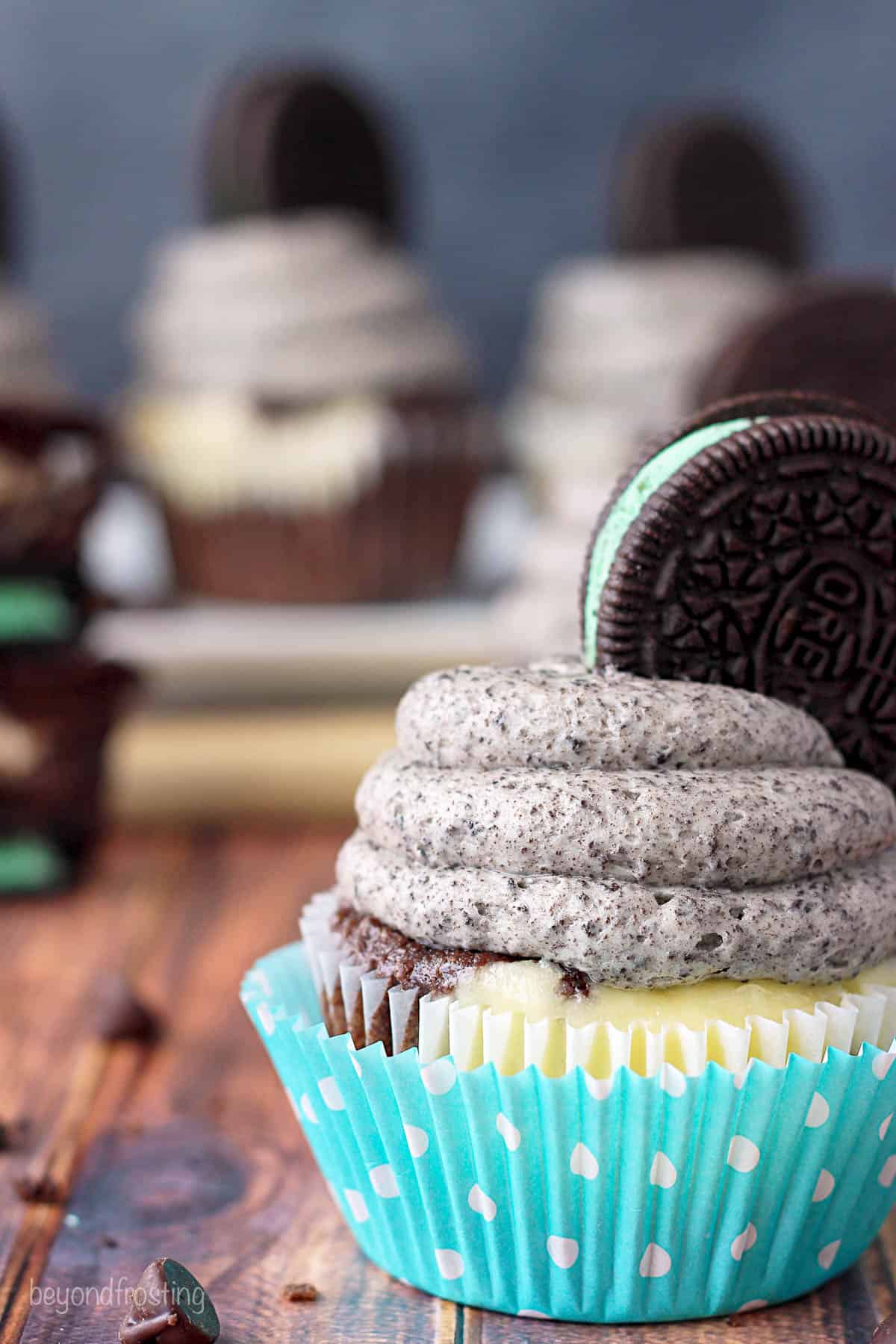 side view of a mint oreo cheesecake cupcake with more cupcakes in the background