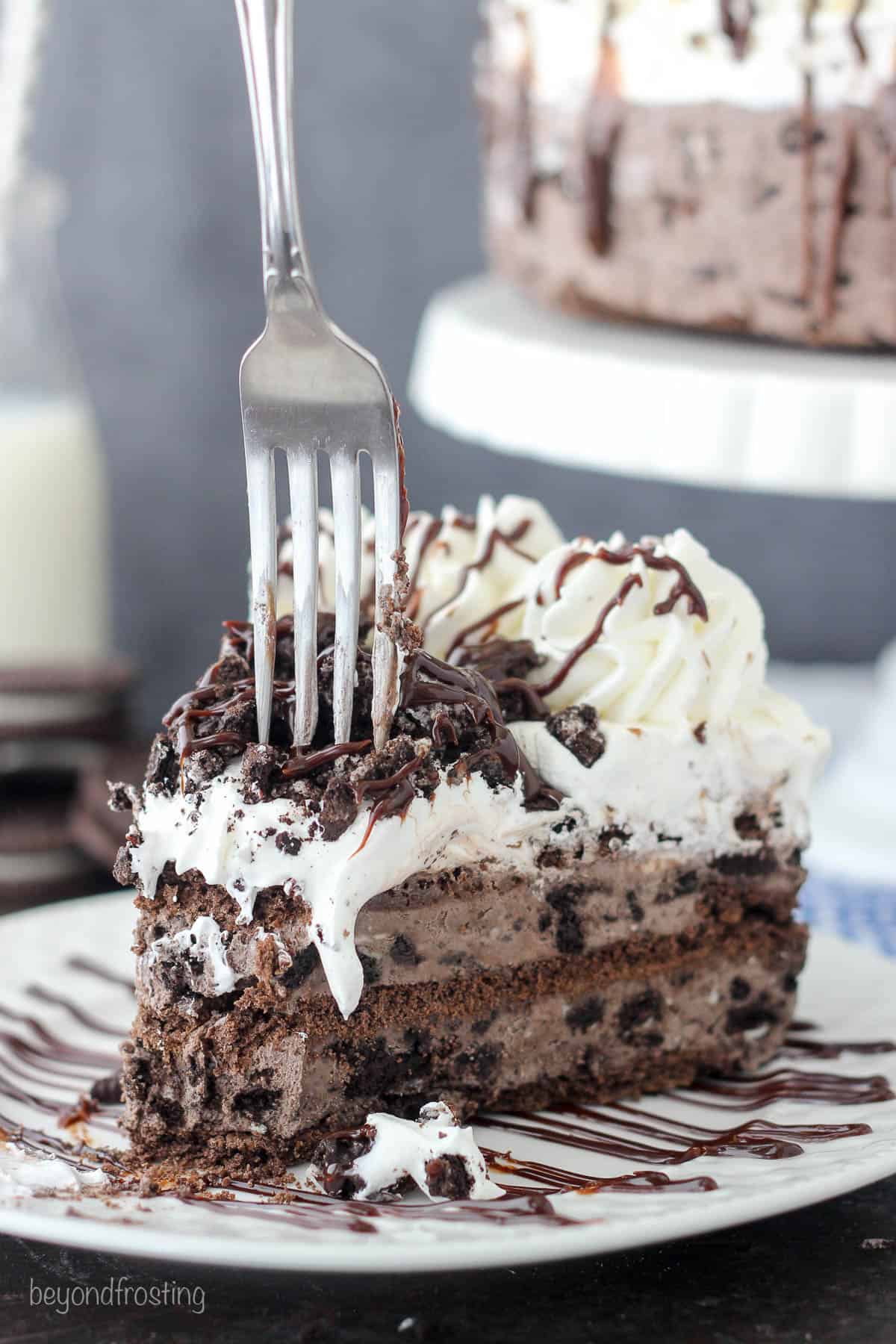 a fork being plunged into a slice of Oreo icebox cake on a plate
