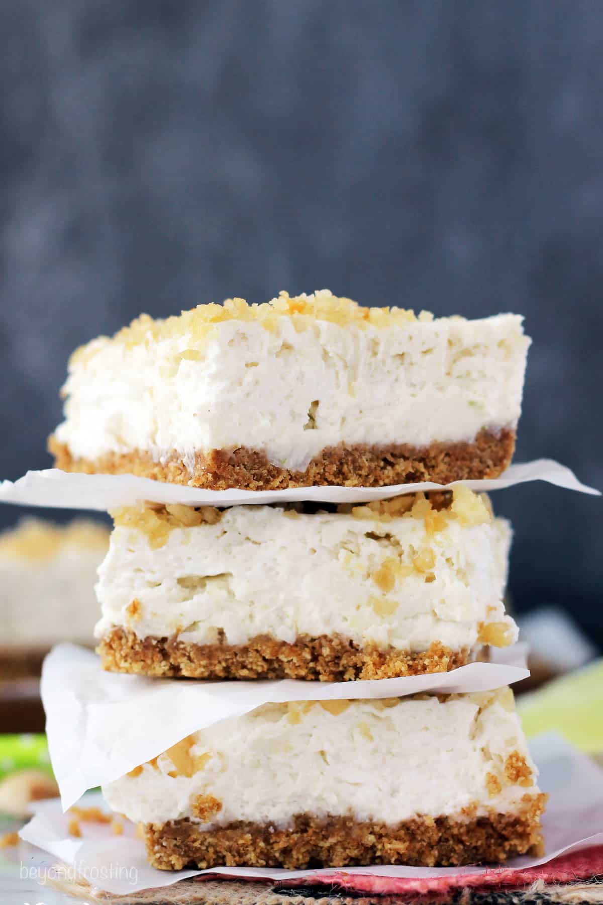 three coconut lime cheesecake bars stacked