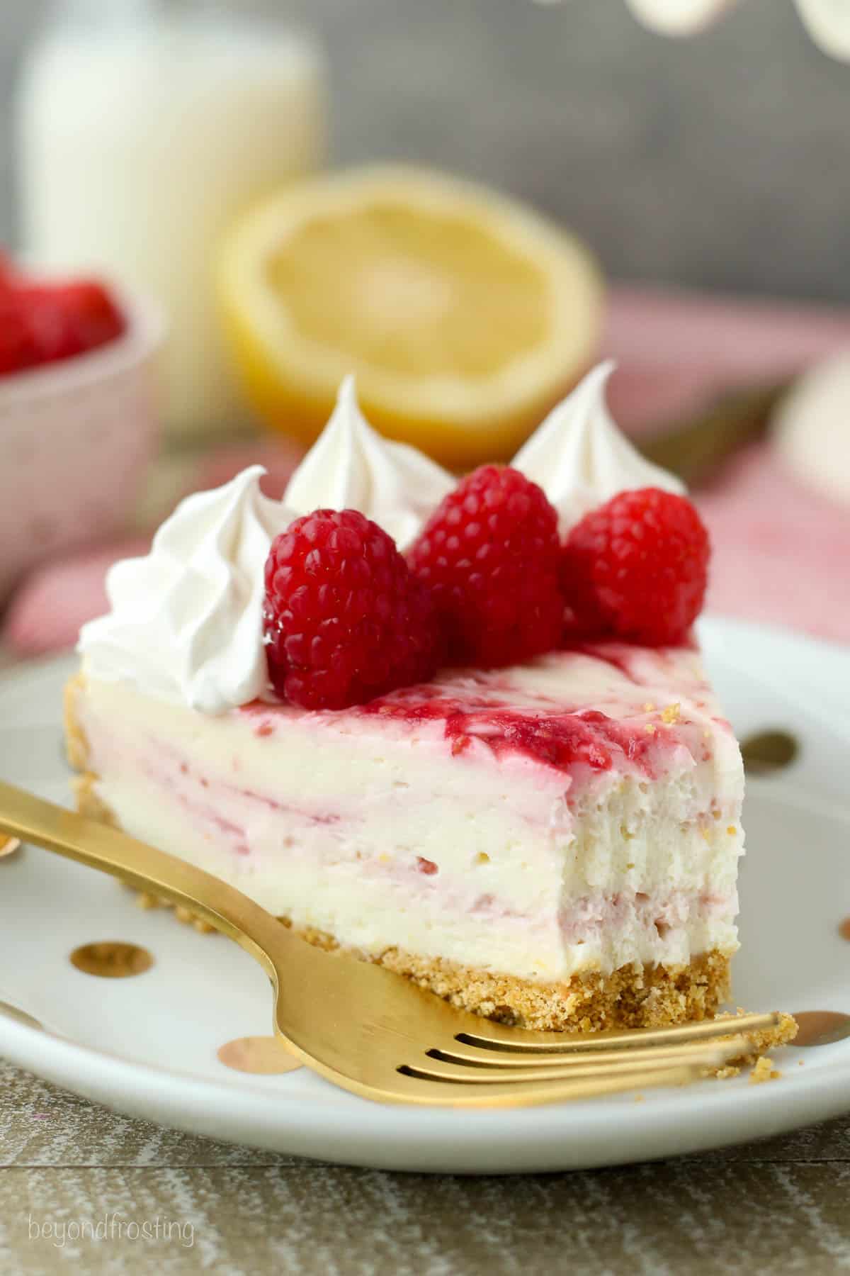 A slice of raspberry cheesecake with a bite missing