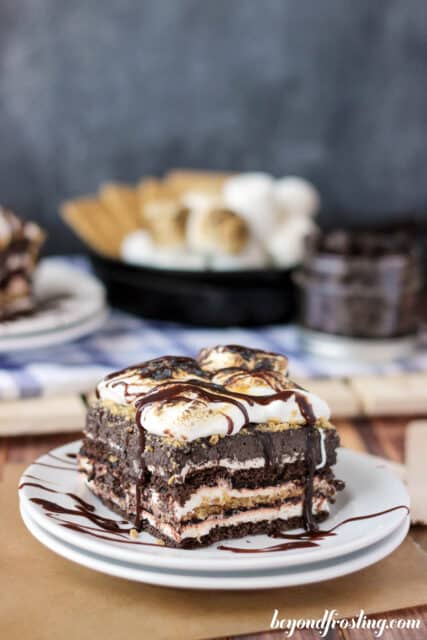 side view of a slice of s'mores icebox cake on a plate drizzled with chocolate