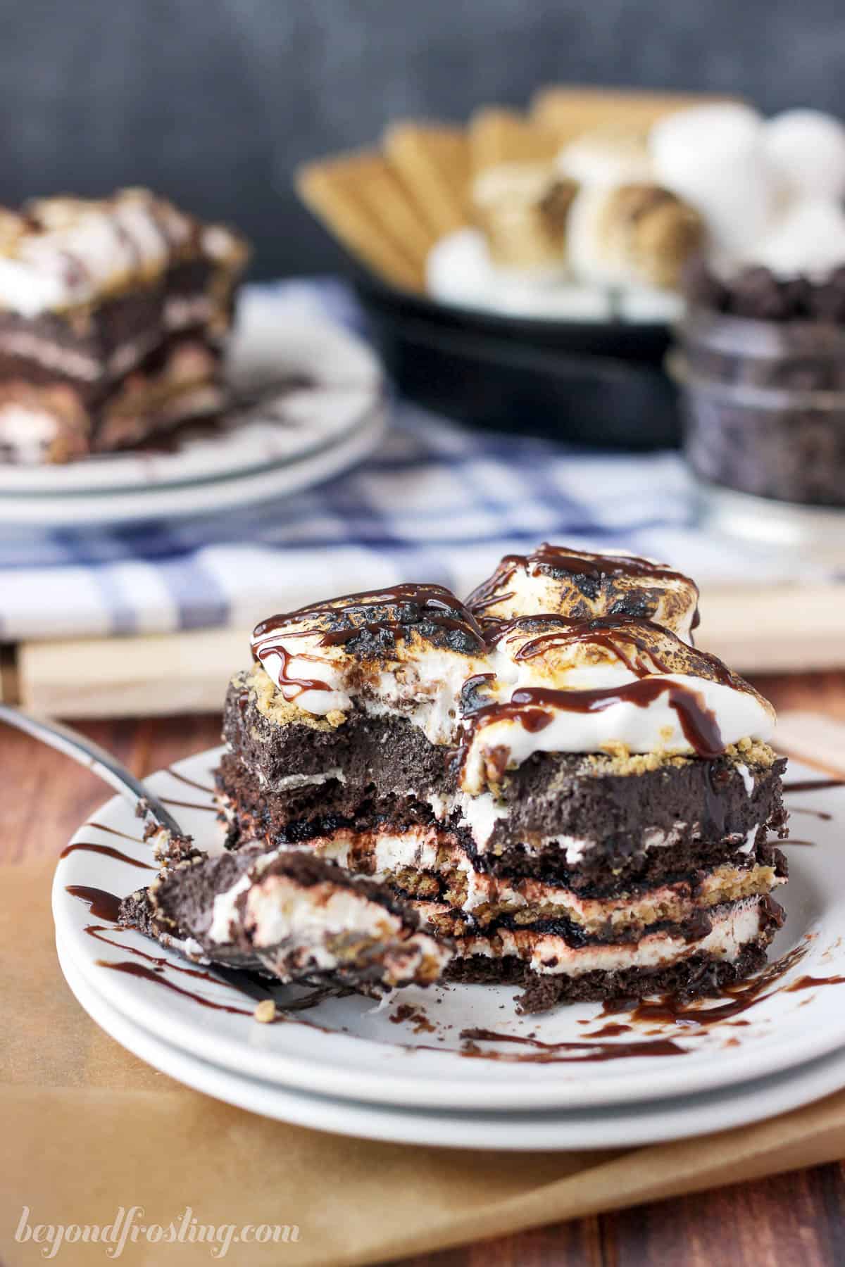 a partially eaten slice of s'mores lasagna on a plate with a fork