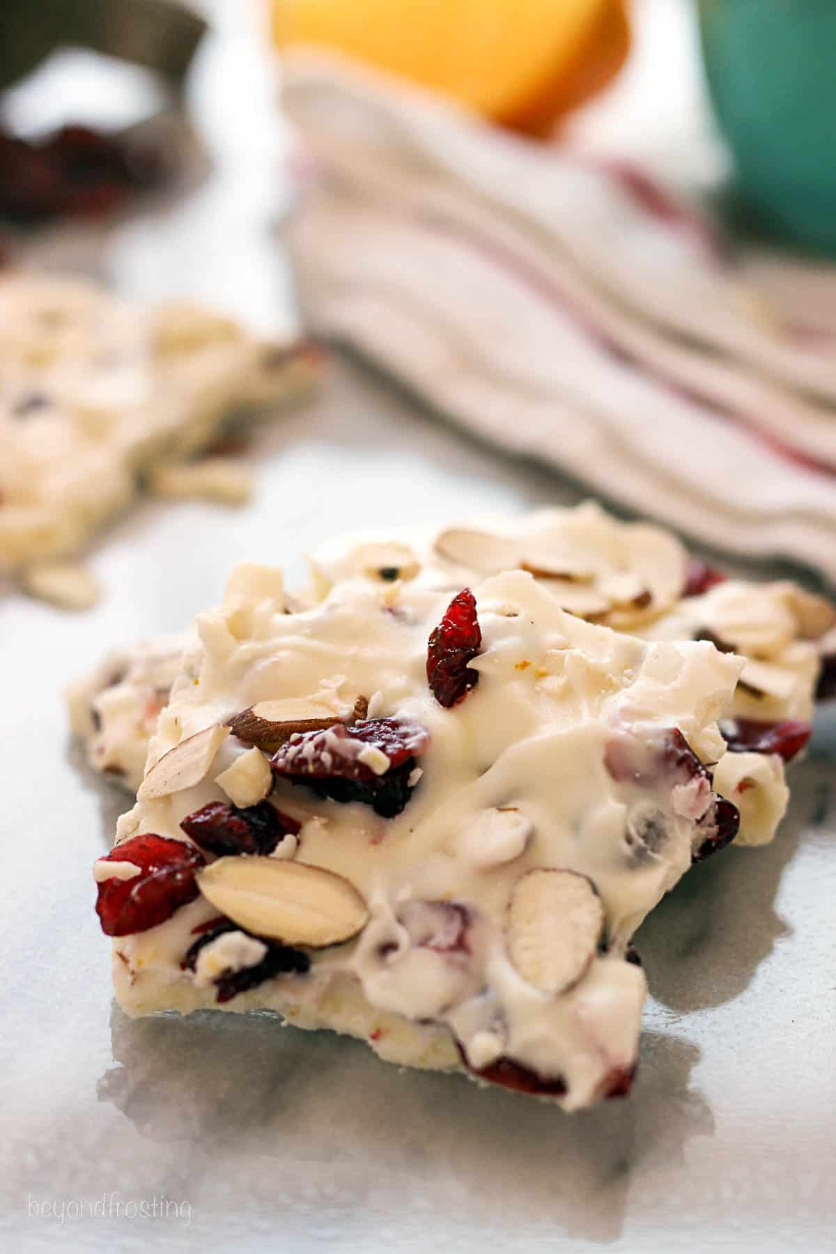 side view of orange cranberry almond bark on the counter
