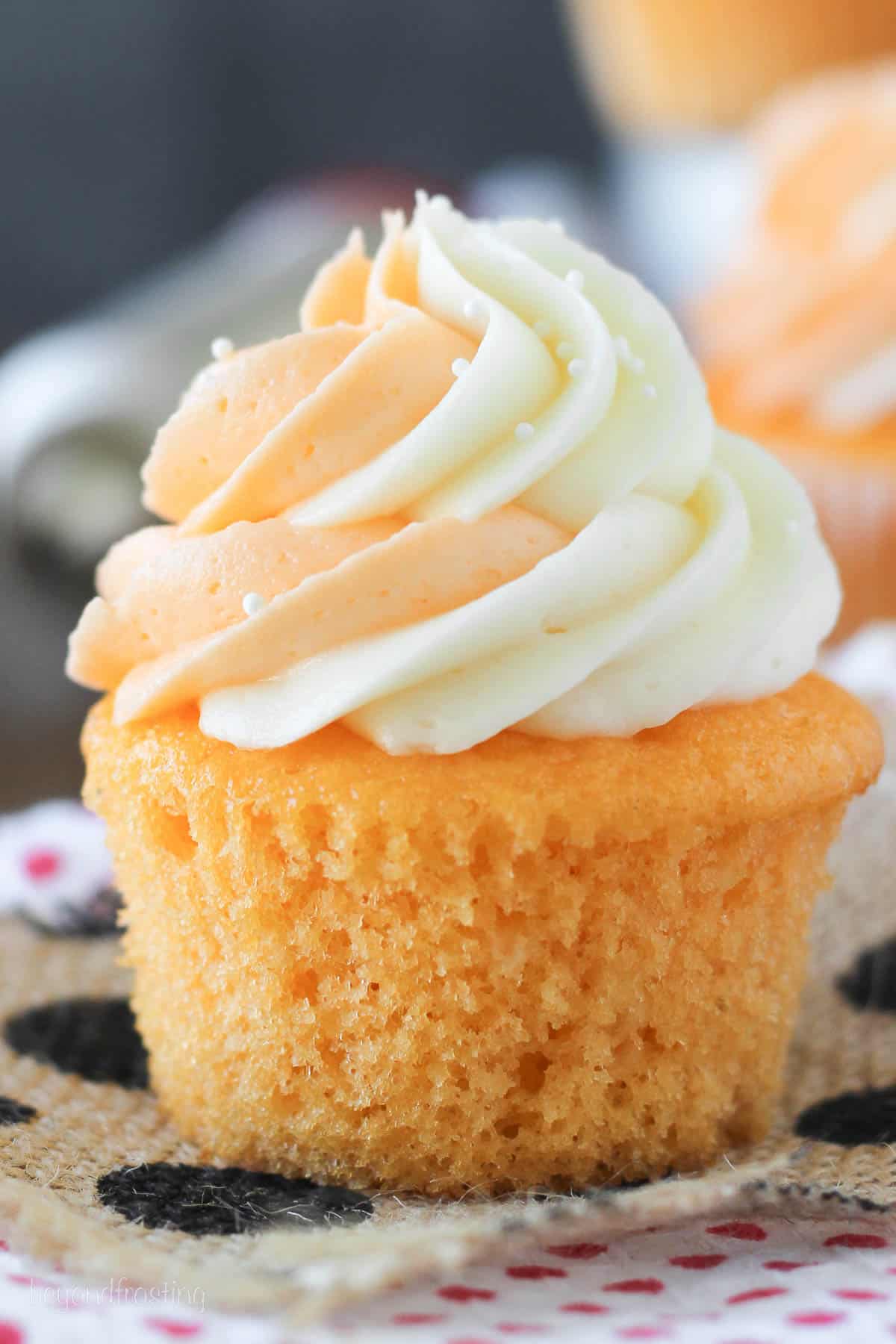 side view of an orange cream cupcake topped with frosting