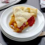 overhead of a slice of peach raspberry pie on a plate