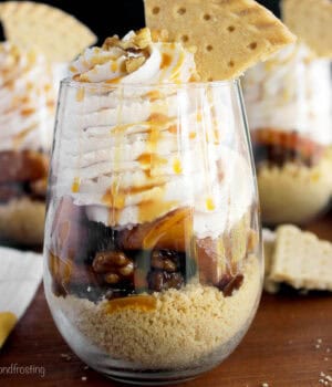 closeup of a glass filled with a peach parfait garnished with a shortbread cookie