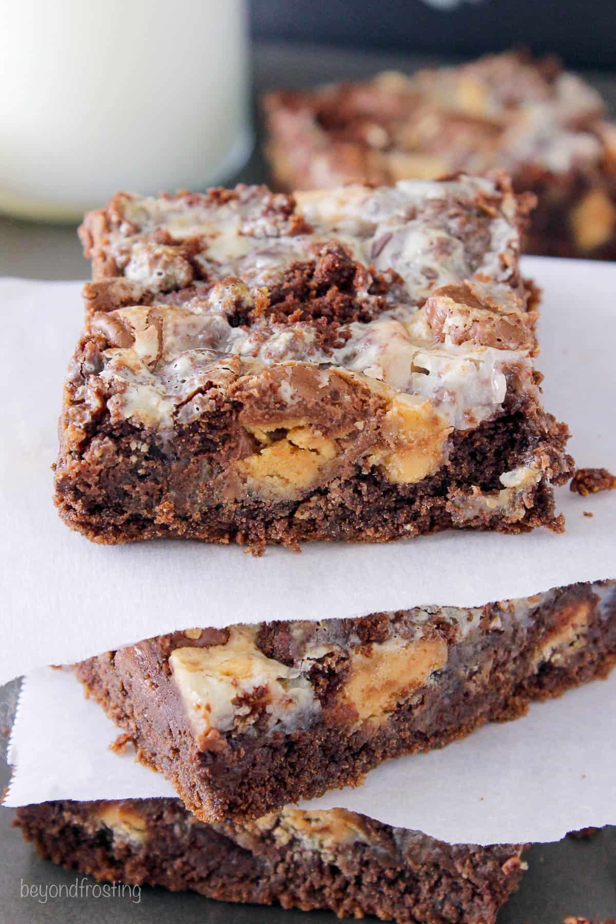 three peanut butter cake bars stacked with parchment paper between each