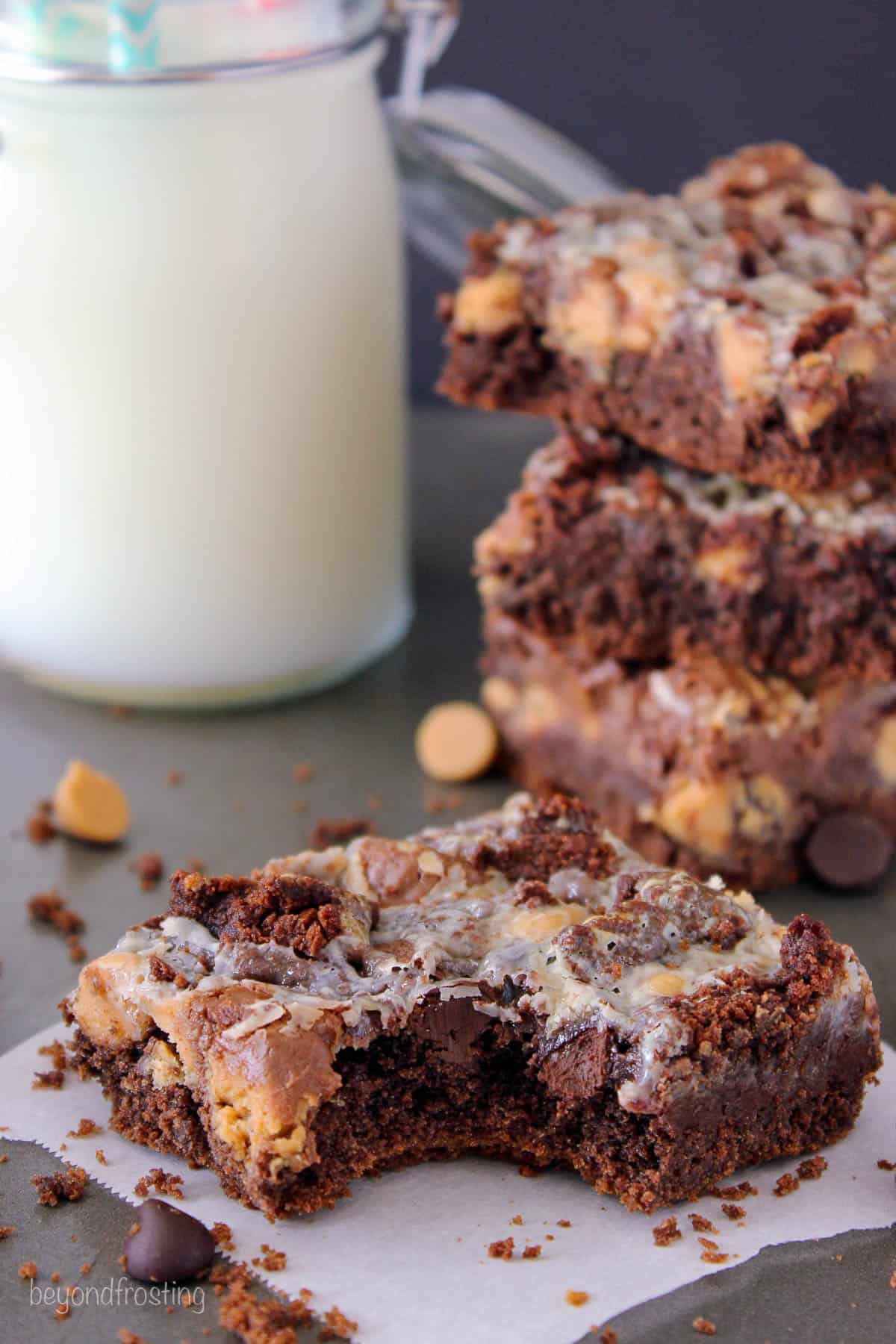 a peanut butter cake bar on a piece of parchment paper with a bite taken out