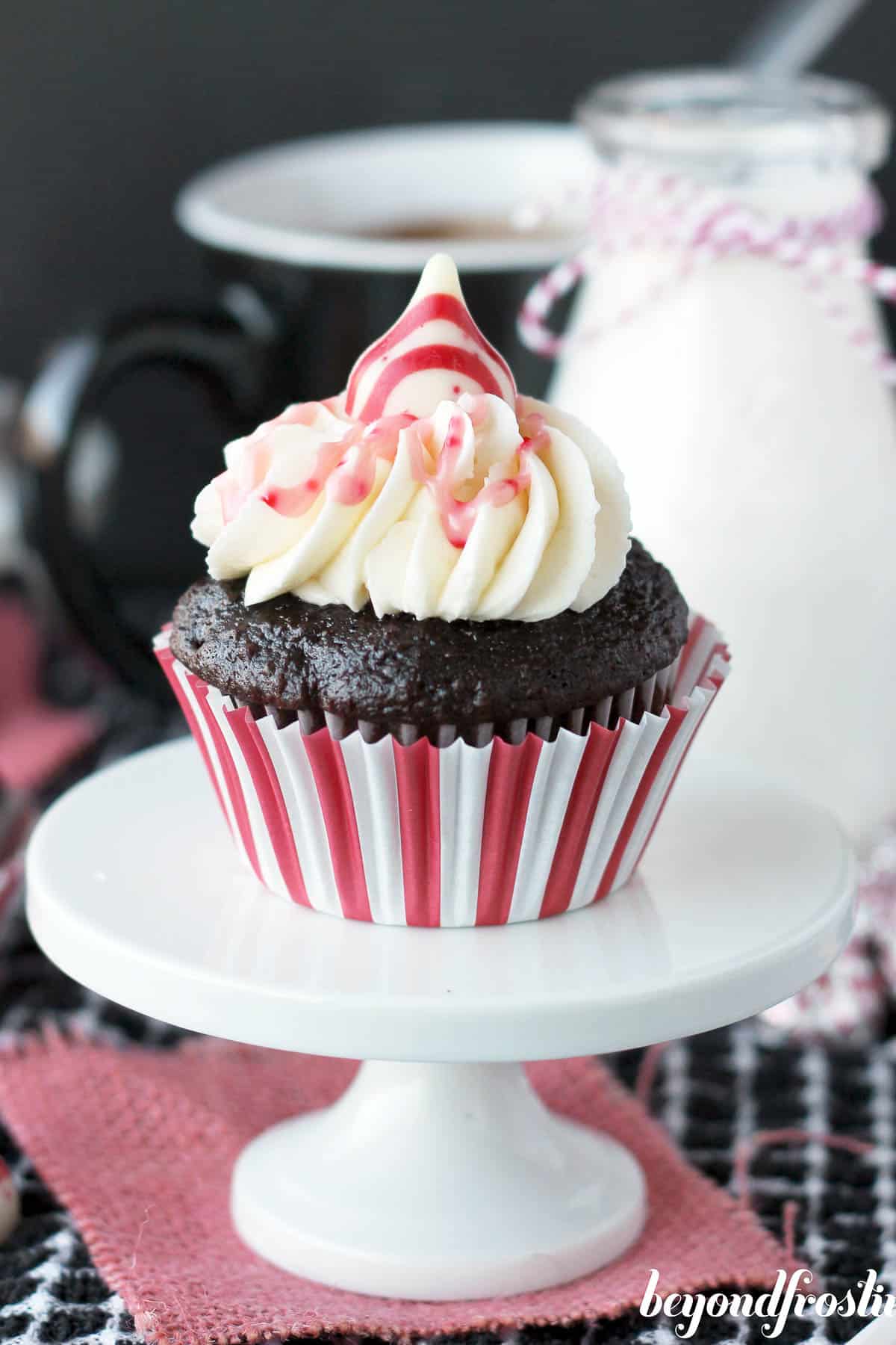 a peppermint hot chocolate cupcake on a cupcake stand