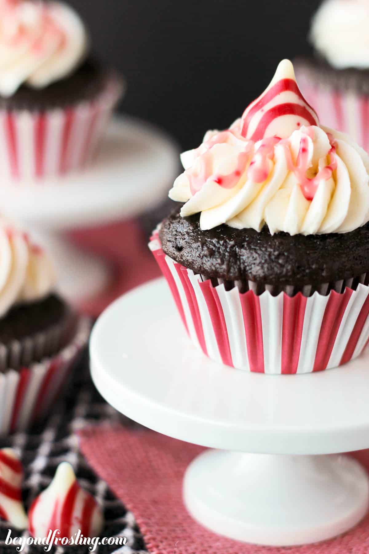 closeup side view of a chocolate peppermint cupcake on a cupcake stand