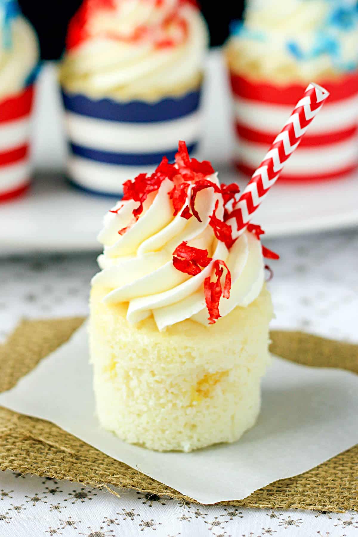 side view of an unwrapped pina colada cupcake topped with frosting