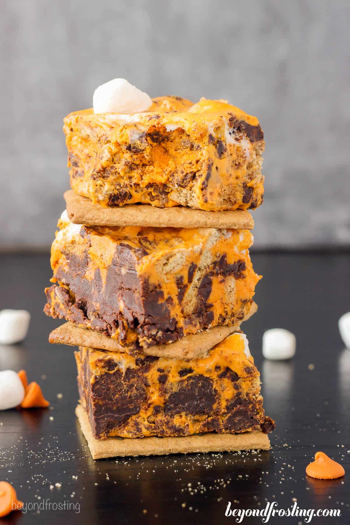 three pieces of pumpkin fudge stacked with a graham cracker between each