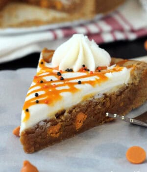 closeup of a slice of pumpkin cookie cake topped with frosting and pumpkin ganache