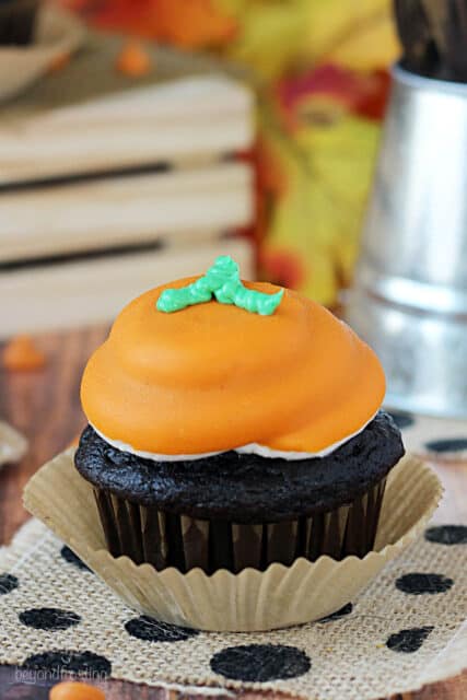 side view of a pumpkin spice cupcake decorated to look like a pumpkin