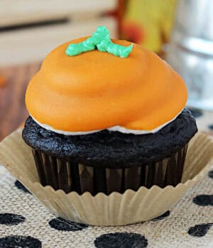 closeup of a pumpkin spice chocolate cupcake decorated to look like a pumpkin