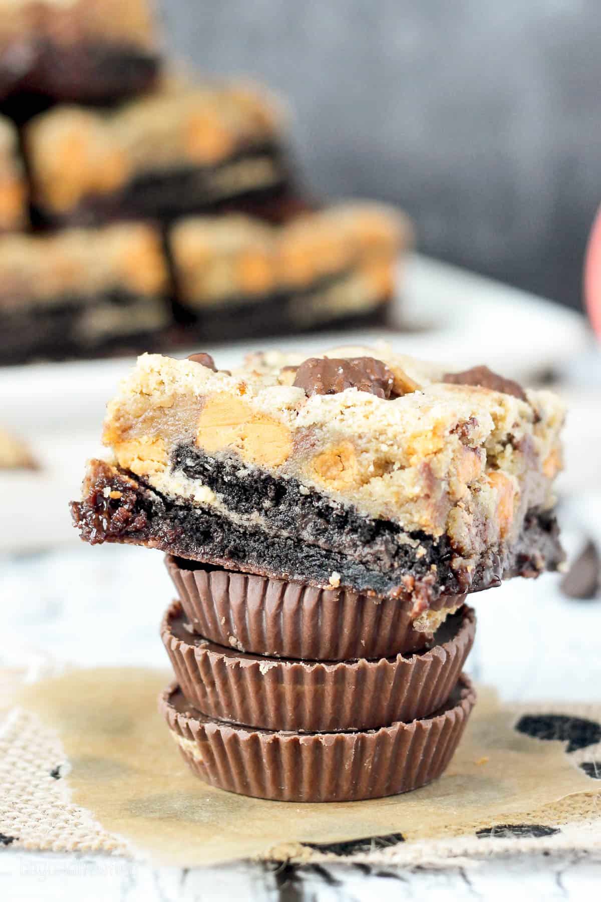 side view of a stack of peanut butter cups topped with a peanut butter brookie