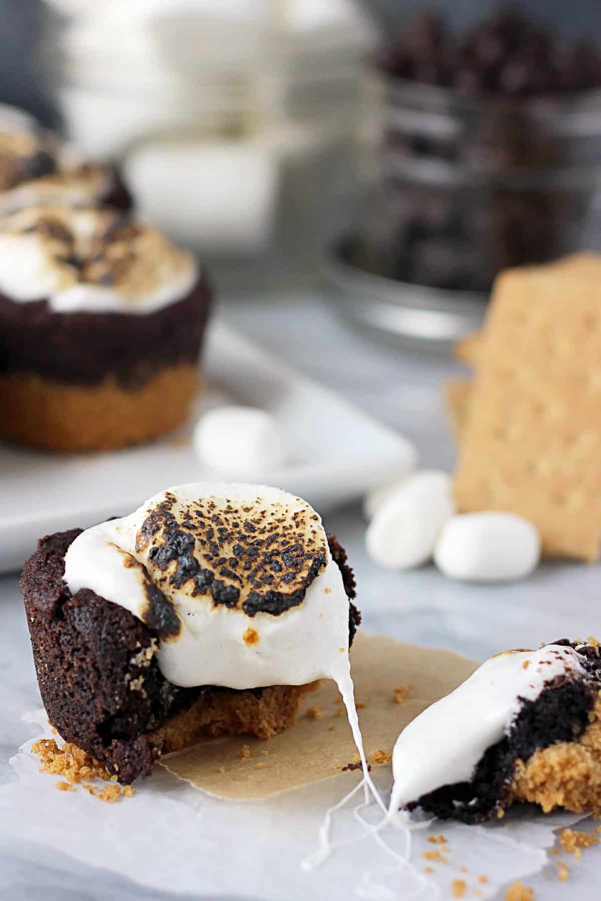 overhead of a broken s'mores cookie cup with a plate of cookie cups in the background