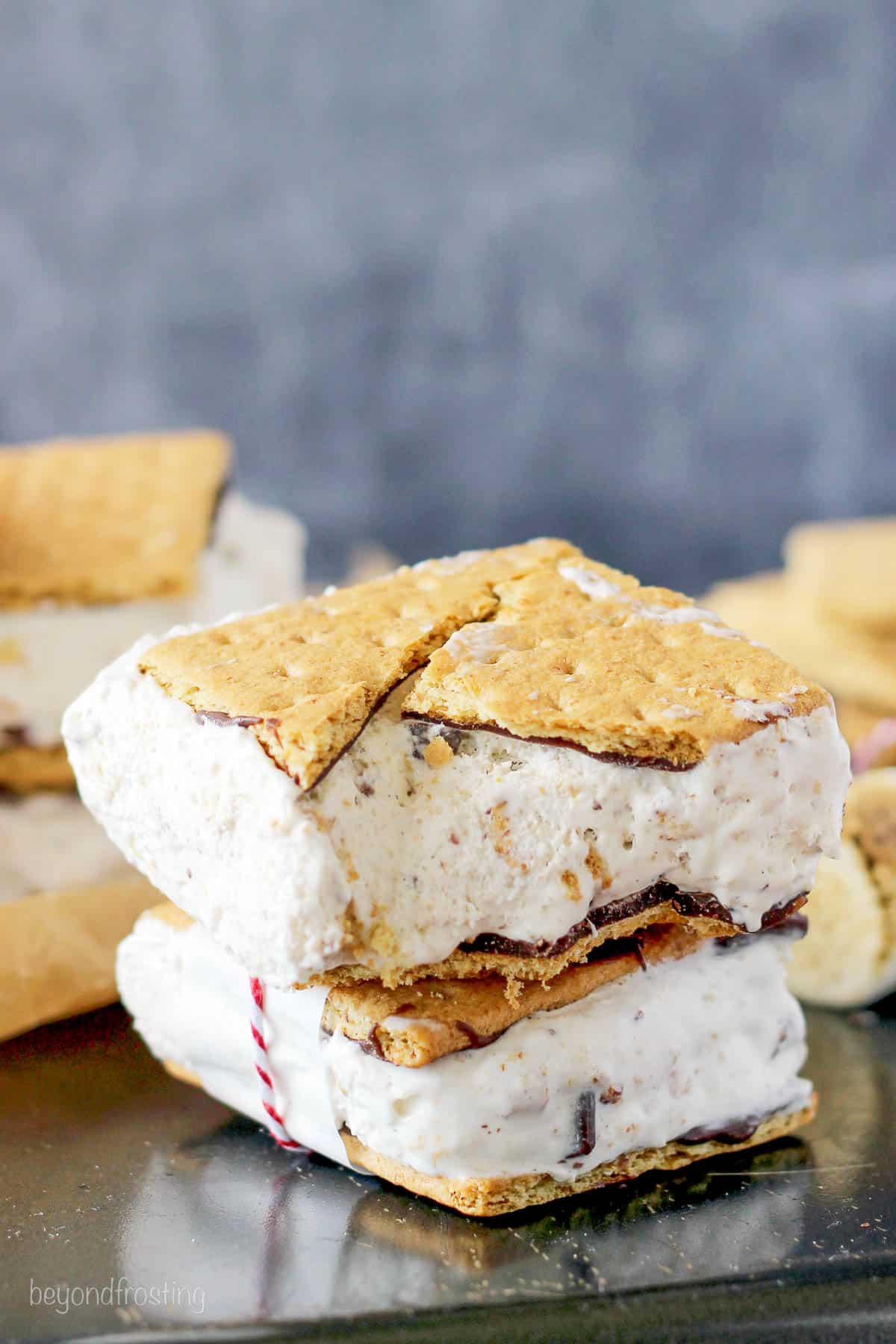 two ice cream sandwiches stacked with a bite taken out of the top one