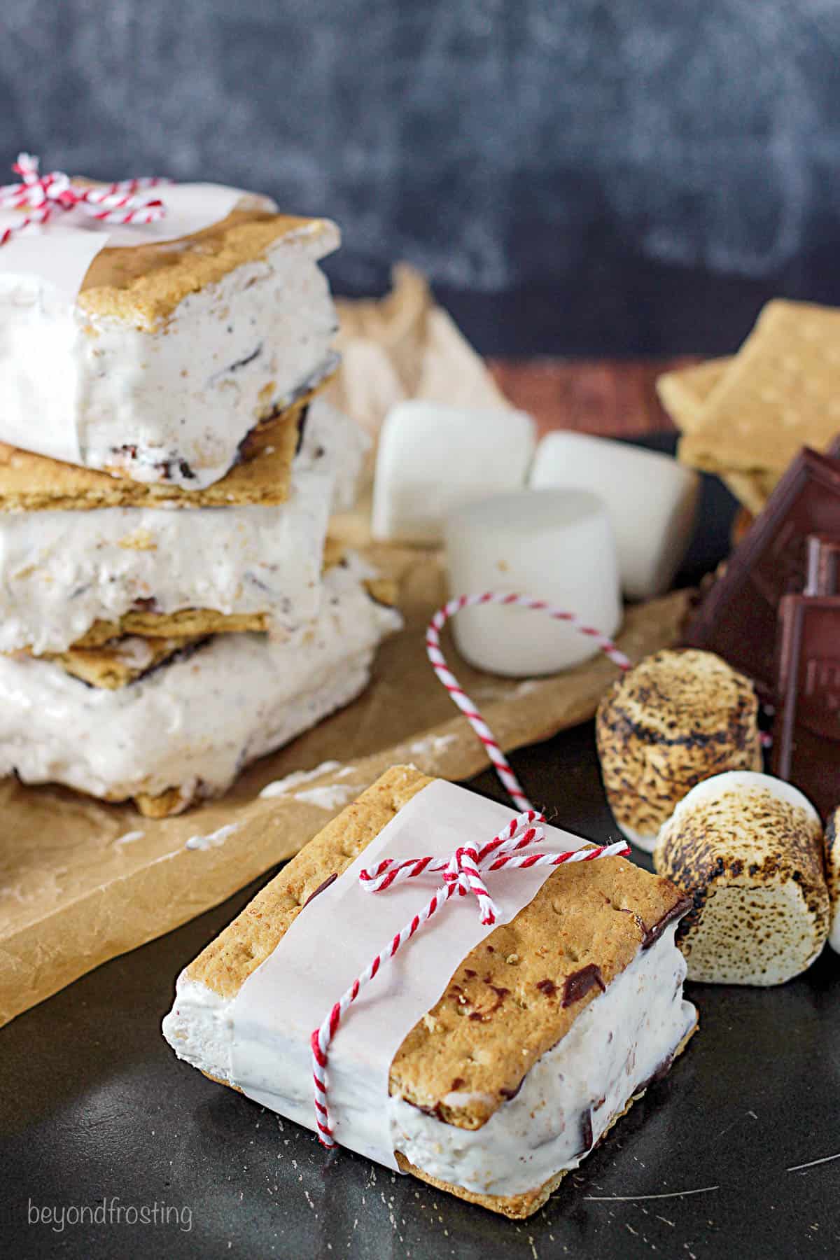 overhead of a s'mores ice cream sandwich on the counter with more stacked on a cutting board in the background