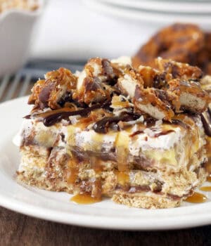 closeup of a slice of samoa icebox cake topped with cookies and caramel
