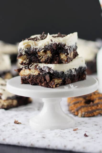 two samoa stuffed brownies stacked on a cupcake stand