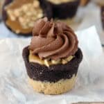 closeup of a snickers cookie cup topped with chocolate frosting