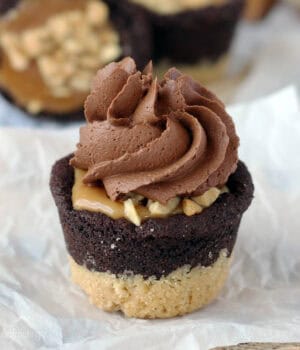 closeup of a snickers cookie cup topped with chocolate frosting