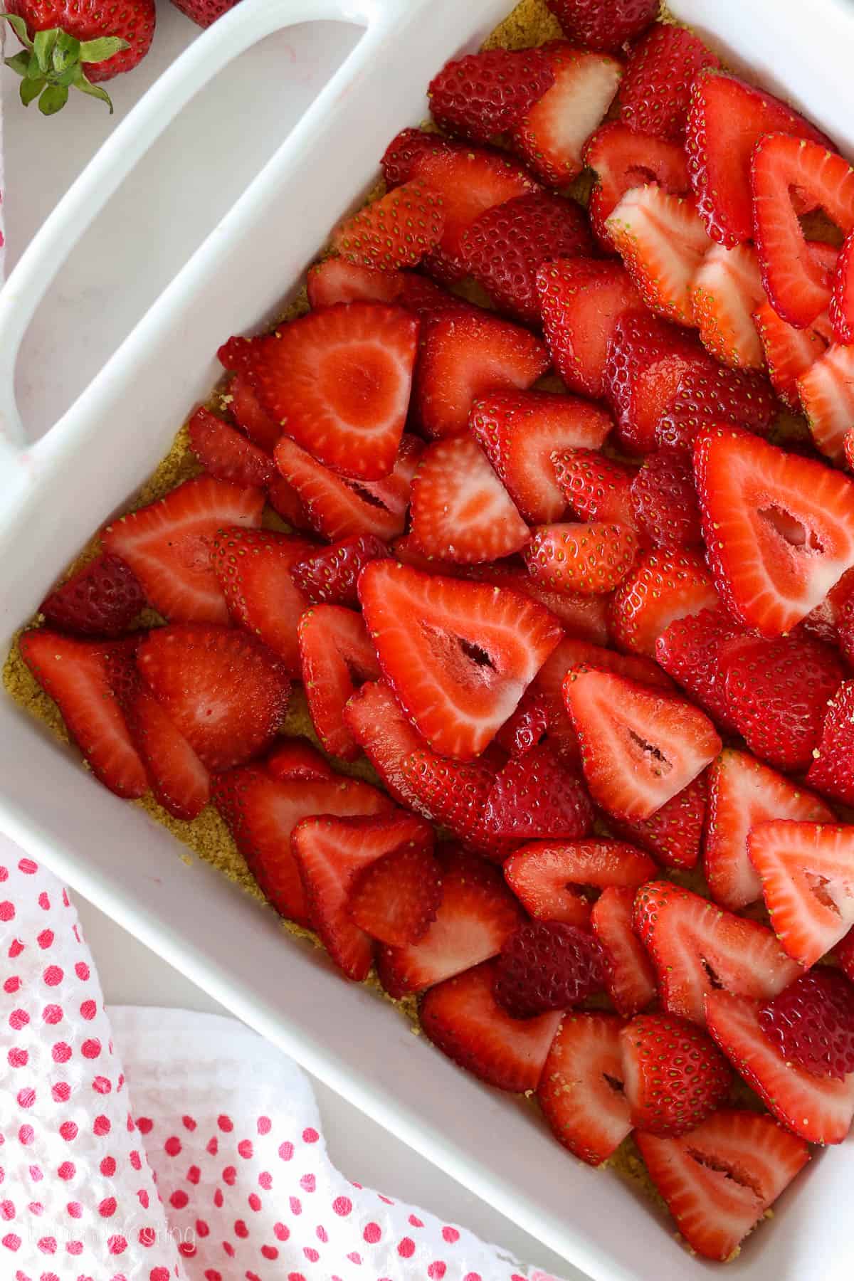 fresh sliced strawberries over top of a graham cracker crust