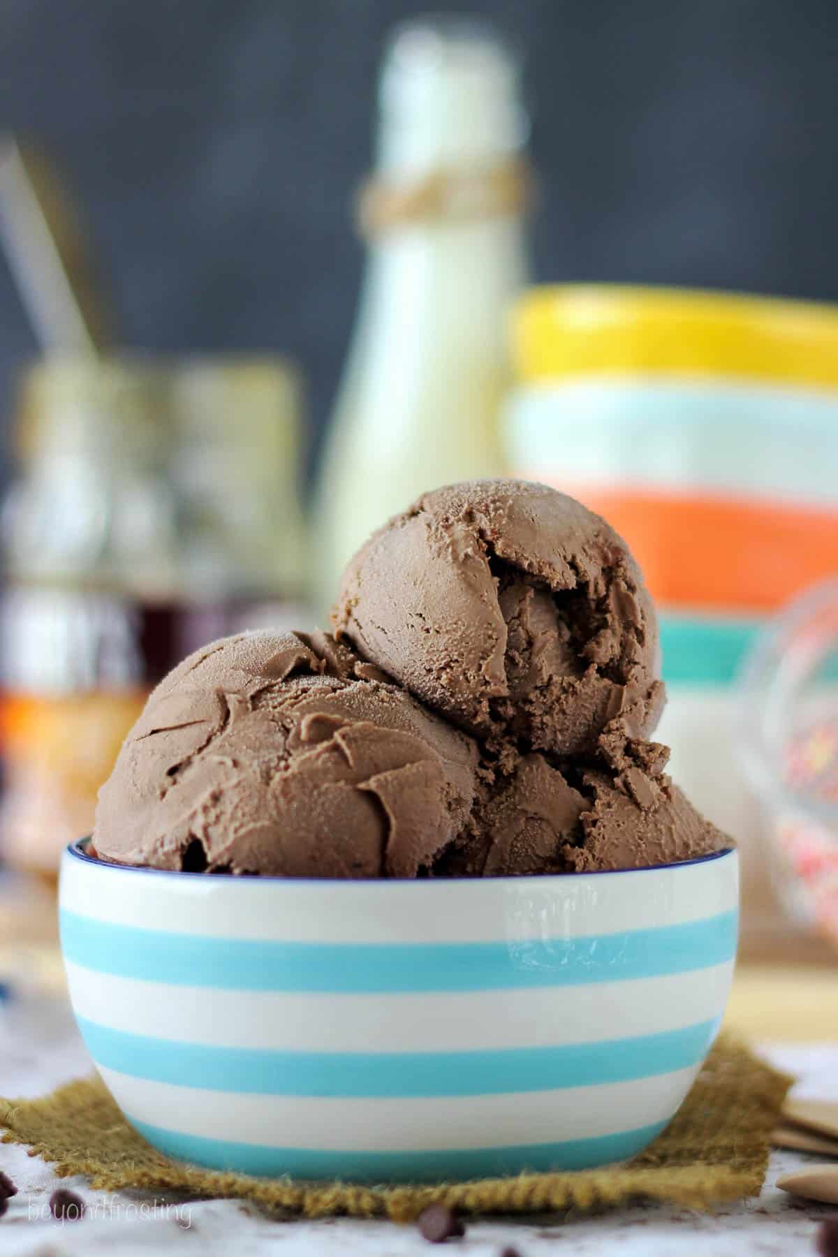 side view of a blue and white striped bowl piled with scoops of salted caramel hazelnut ice cream