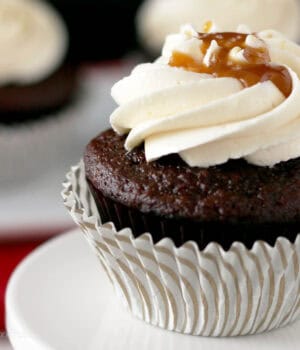 closeup of a chocolate cupcake topped with frosting and caramel