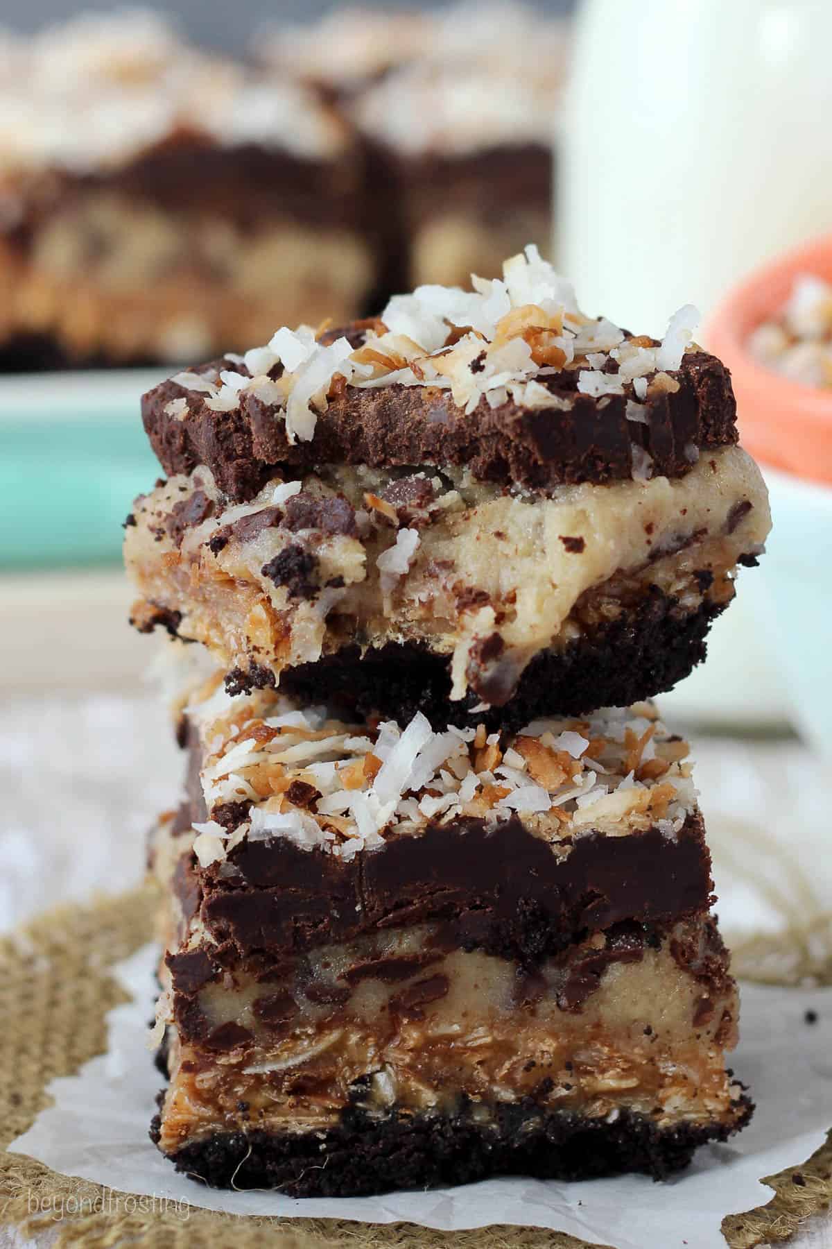 side view of two cookie dough bars stacked with a bite taken out of the top one
