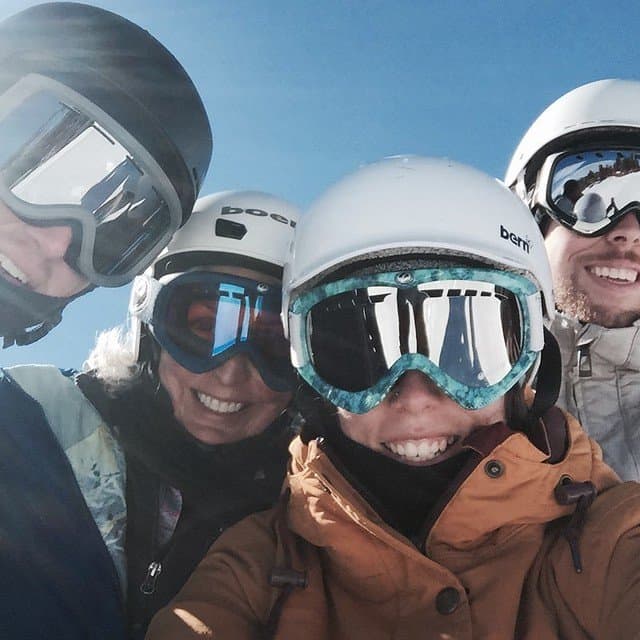 Selfie of four friends with ski helmets and goggles