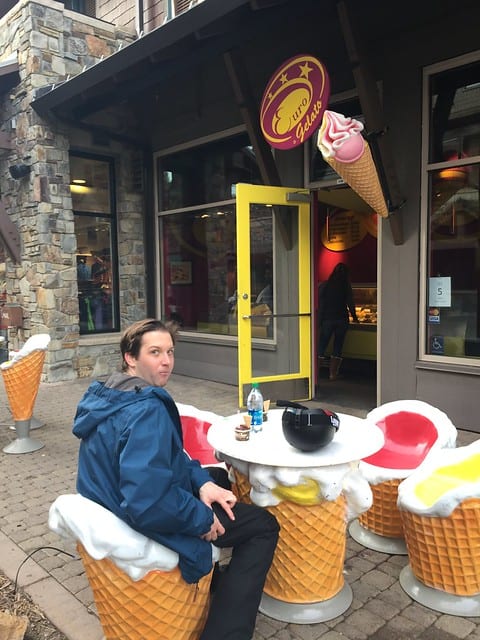 Author's partner sitting on waffle cone seats outside a gelato shop