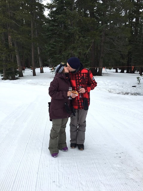 Blog author and her partner kissing on a ski slope
