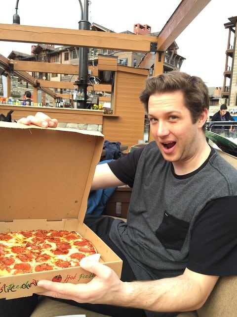 Blog author's partner holding a pepperoni pizza in a box