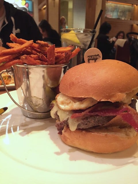 Close-up of a burger and sweet potato fries from Holstein's restaurant