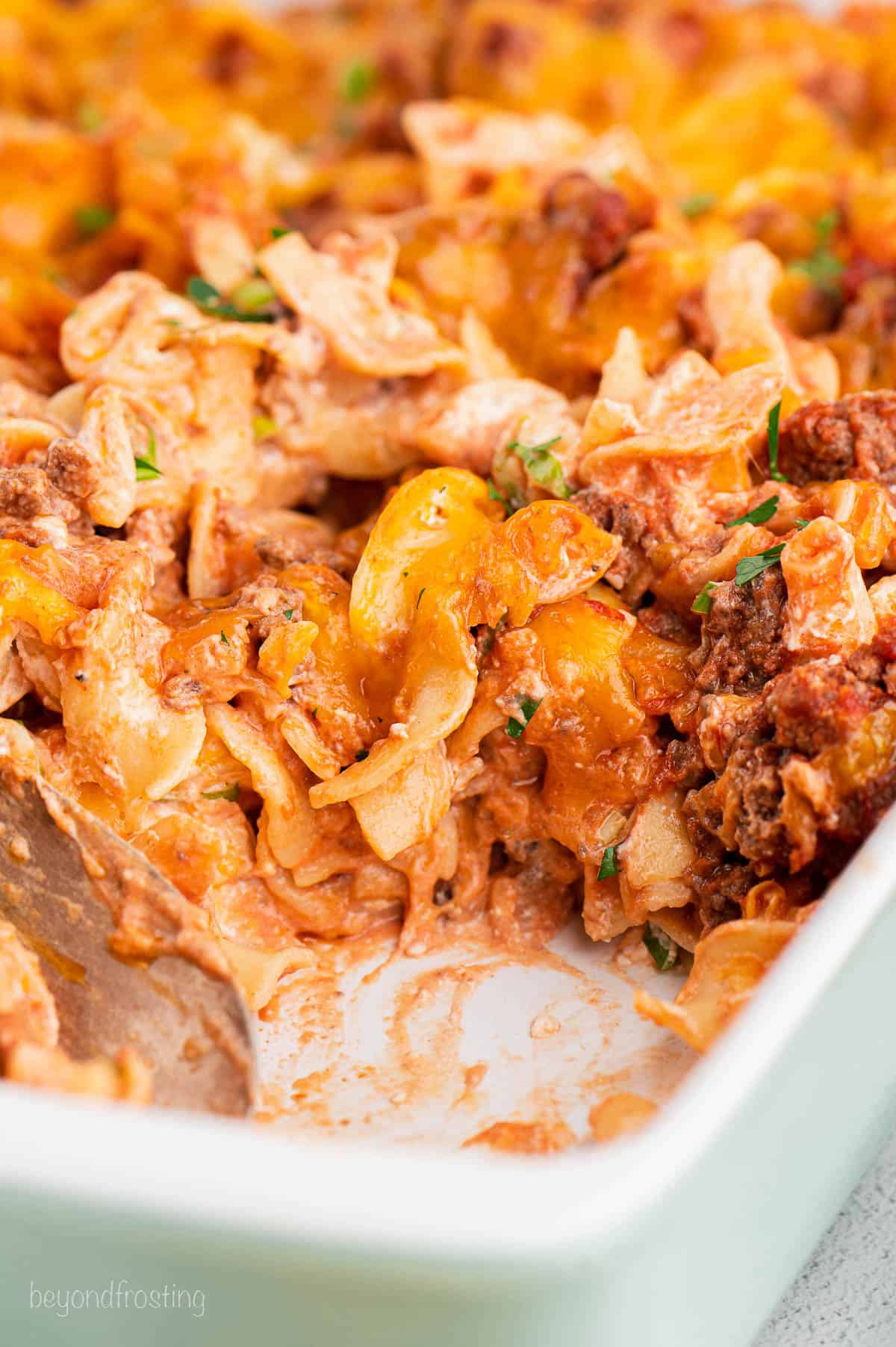 Close up of ground beef noodle casserole in a baking dish