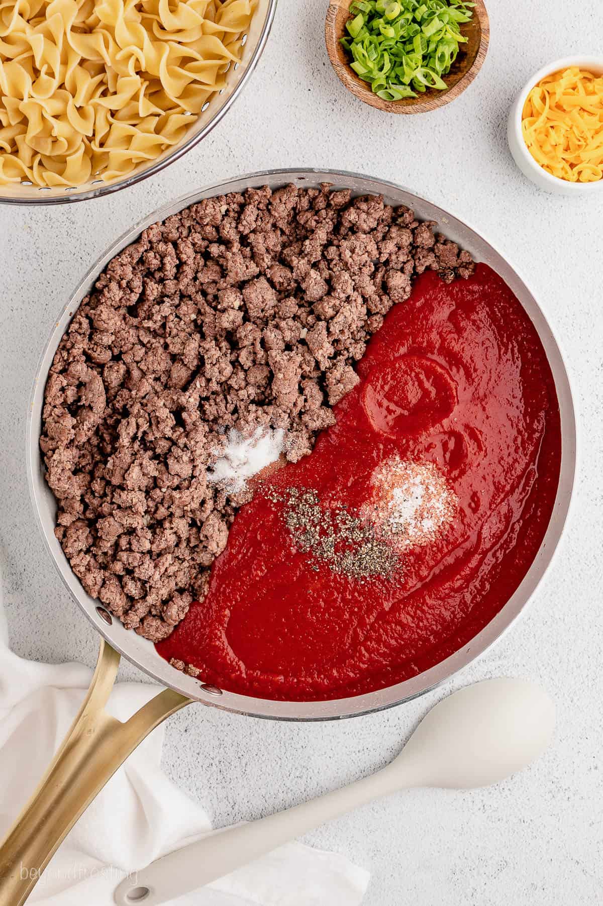 Tomato sauce, ground beef, and seasonings in a pan
